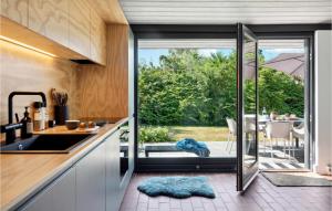 eine Küche mit einer Glasschiebetür, die auf eine Terrasse führt in der Unterkunft Nice Home In Odder With Wifi in Odder