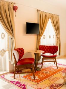 een woonkamer met 2 stoelen en een tafel bij Boutique Burgaz Otel in Selcuk