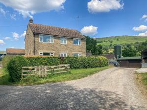 a house with a fence on the side of a road at Carr View Farm in Bamford