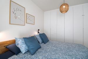 a bedroom with a bed with blue pillows at Paramount views Agaete apartment in Puerto de las Nieves