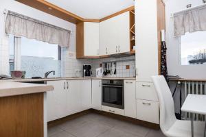 a kitchen with white cabinets and a stove top oven at Two bathrooms Free parking Beds for 9 pers Great view in Grundarfjordur