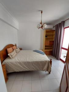 ein weißes Schlafzimmer mit einem Bett und einem Fenster in der Unterkunft Apartamento Batalha - Quarteira, Algarve, Portugal in Quarteira