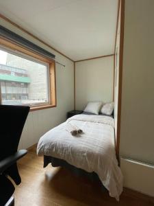 ein kleines Schlafzimmer mit einem Bett und einem Fenster in der Unterkunft City Center Stylish Loft in Trondheim