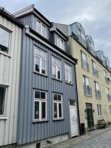a gray building with white windows on a street at City Center Stylish Loft in Trondheim