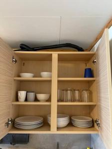 a cabinet filled with plates and bowls on shelves at City Center Stylish Loft in Trondheim