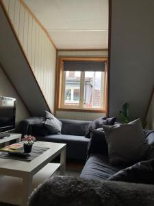 a living room with two couches and a table at City Center Stylish Loft in Trondheim