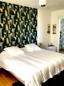 a bedroom with a large white bed with a colorful headboard at VUE LAC LODGES in Sévrier