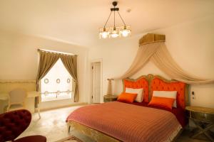 a bedroom with a bed with orange pillows and a window at B&Y Burgaz in Selcuk
