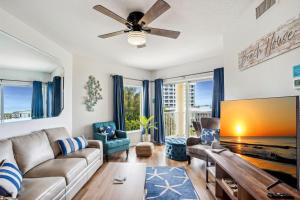 a living room with a couch and a ceiling fan at Sunset Vistas 407S in St Pete Beach