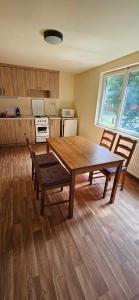 a room with a wooden table and a kitchen at Álomvölgy in Mány