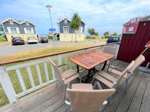 a wooden table and chairs on a deck with houses at Strandpark Sierksdorf H080 in Sierksdorf
