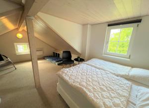 a attic bedroom with a bed and a window at Strandpark Sierksdorf H080 in Sierksdorf