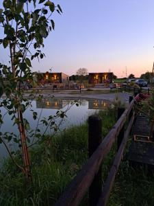 un estanque en un campo con un edificio al fondo en Pond Beach Oak residence, 