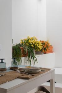uma mesa com placas e vasos de plantas na parede em A Casa de Cima - Cacela Velha em Vila Nova de Cacela
