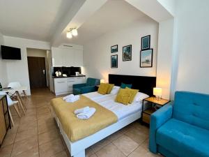 sypialnia z łóżkiem i niebieską kanapą w obiekcie Apartamenty Planeta Mielno 100 m od plaży w mieście Mielno
