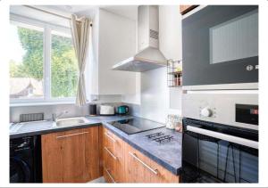 a kitchen with a stove and a sink and a window at Studio calme dans un château au coeur de Caen in Caen