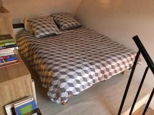 a bed with a black and white comforter in a room at Loft à Tours Nord in Tours