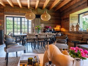 un comedor con mesas, sillas y ventanas en Superbe ferme rénovée en chalet de luxe en PLEINE NATURE, en Barcelonnette