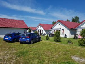 two cars parked in front of a house at Domki letniskowe Reda in Rusinowo