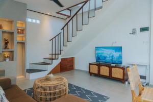 a living room with a staircase and a tv at Villa Gading in Ubud