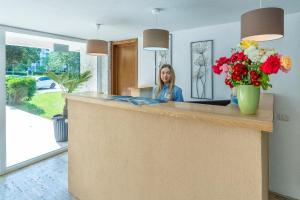 a woman sitting at a counter with flowers at Mera Holiday Resort in Venus