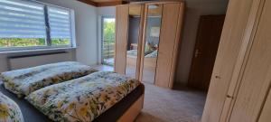a bedroom with two beds and a mirror at Moderne120qm Ferienwohnung in ruhiger Lage Heusweiler - Saarland in Heusweiler +27 photos