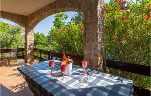 een tafel met een blauw tafelkleed en rode glazen bij 2 Bedroom Lovely Apartment In Pinezici in Pinezici