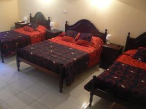 Un dormitorio con 2 camas y un banco. en Hotel JSF, en Horta