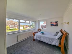 a bedroom with a bed and two windows at Solent View in Seaview