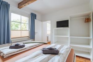 two beds in a room with a window at Appartments Am Goldberger See in Goldberg