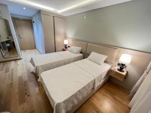 Habitación de hotel con 2 camas y espejo en Sezer's Oliva Hotel, en Canakkale