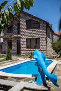 una estatua de delfín azul junto a una piscina en Sweet Home en Yengidzha