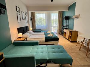 une chambre avec deux lits et un canapé dans l'établissement Apartament 205 Planeta Mielno 100 m od plaży, à Mielno