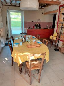 einen Tisch in einer Küche mit einem gelben Tischtuch in der Unterkunft Chambres d'hôtes au calme 