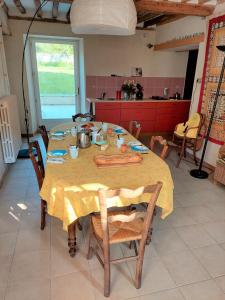 une table dans une cuisine avec un chiffon de table jaune dans l'établissement Chambres d'hôtes au calme, 