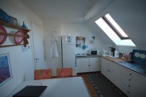 a kitchen with a white refrigerator and a table at Bed & Kitchen i Højer in Højer