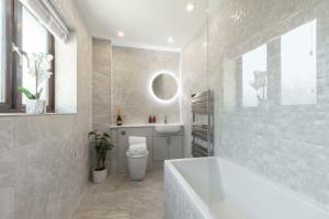 a bathroom with a tub and a toilet and a sink at Stunning Five Bed Detached Home in Golden Valley