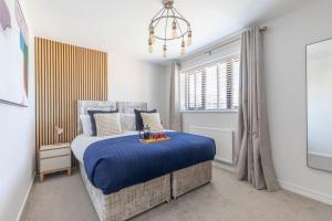 a bedroom with a blue bed and a window at Stunning Five Bed Detached Home in Golden Valley