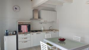 a kitchen with white cabinets and a table and a counter at Santa Croce in Fanano