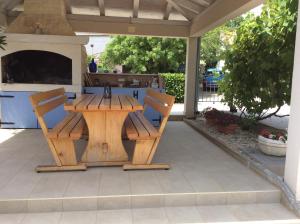 een houten tafel en stoelen op een patio bij Apartment Pin in Pinezici