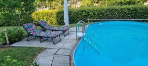 two chairs and a swimming pool with two chairs at Moderne120qm Ferienwohnung in ruhiger Lage Heusweiler - Saarland in Heusweiler