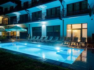 a villa with a swimming pool at night at Hotel Paryski Art & Business Zakopane - Basen Jacuzzi Sauna Małpi Gaj in Zakopane