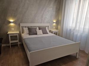 1 dormitorio con 1 cama blanca y 2 mesitas de noche en City Center Apartment, en Termoli