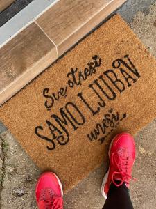 a person in pink shoes writing a sign on a sidewalk at Magia di montagna in Žabljak