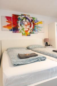 two beds in a room with paintings on the wall at #3 bequemes Zimmer mit Pool und Garten in Memmingen