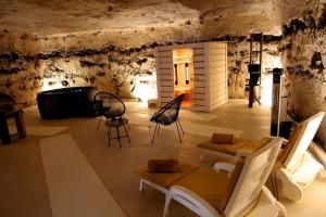 um quarto com cadeiras e uma banheira numa caverna em La suite des fouleries em Châteaudun