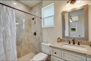 a bathroom with a toilet and a sink and a mirror at Beach Downtown Pet-friendly 1 BD @ The Park-633 in Sarasota