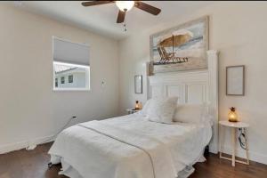 um quarto branco com uma cama e uma ventoinha de tecto em Beach Downtown Pet-friendly 1 BD @ The Park-633 em Sarasota