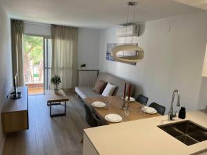 eine Küche und ein Wohnzimmer mit einem Tisch und einem Sofa in der Unterkunft Nice new flat near the beach in Lloret de Mar