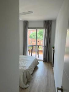 Schlafzimmer mit einem Bett und Blick auf einen Balkon in der Unterkunft Nice new flat near the beach in Lloret de Mar